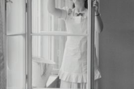 Schwarzweiß Bild einer Frau die Fenster putzt