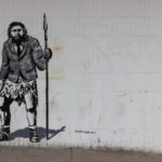 Graffiti Steinzeitmensch mit Aktentasche